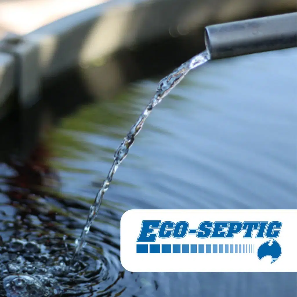 A metal pipe pours clear water into a basin, creating gentle ripples on the surface. The image has a logo in the lower right corner that reads "ECO-SEPTIC" in blue letters accompanied by a graphic of a droplet, highlighting their domestic and commercial AWTS solutions.